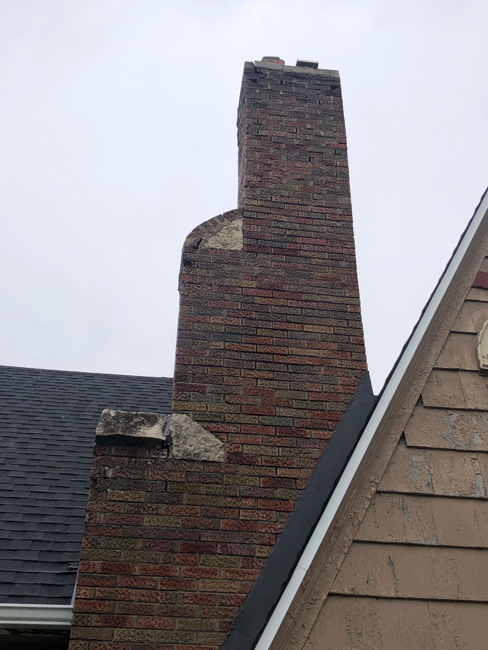 Before: Old chimney with failing stone veneer — re-wrapped in thin brick for a clean, modern look.