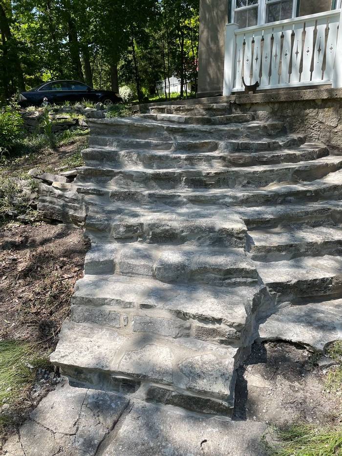 After: Every stone in these lake-house steps was loose. Rebuilt from the footing up with proper drainage.