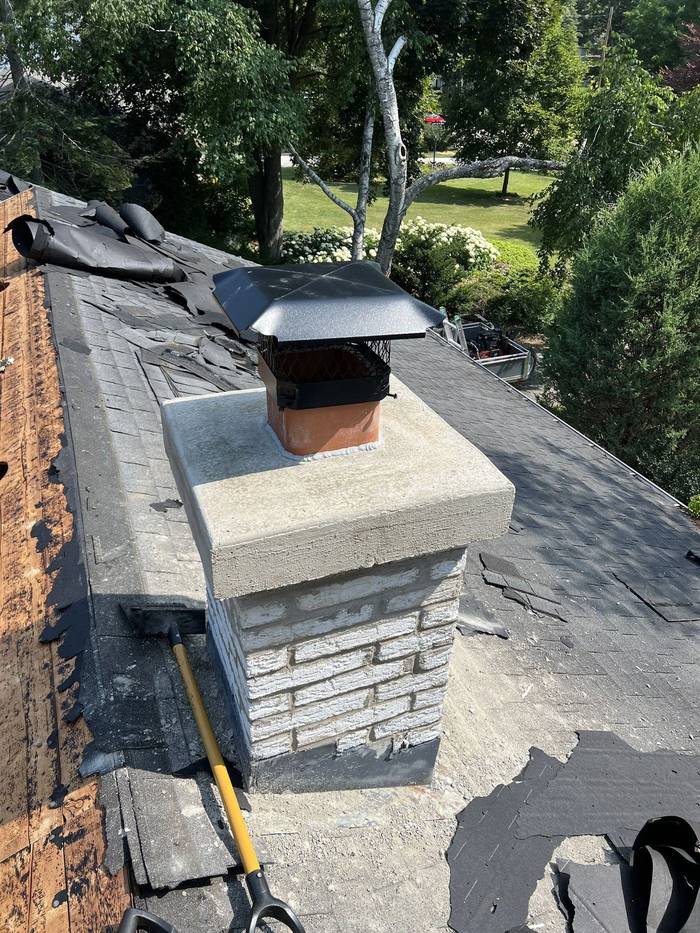 Rebuilt chimney with a new poured crown and stainless cap, completed by Watertight Masonry