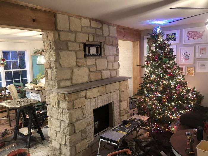 Living room fireplace rebuilt floor to ceiling in cut stone, masonry finished, room still under construction